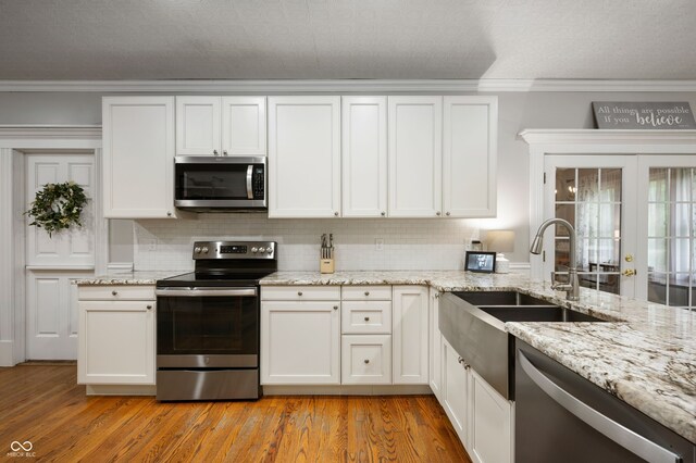 2708 N 400 E, Greenfield, IN 46140 - kitchen featuring stainless steel appliances, a sink, light wood-type flooring, decorative backsplash, and crown molding