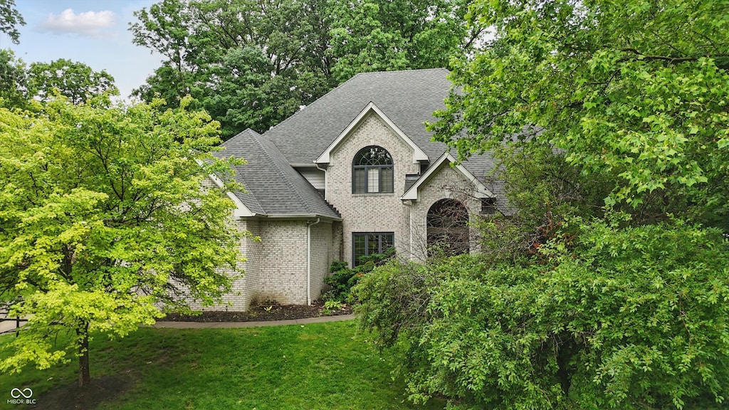 7138 Nile Ridge Ct, Indianapolis, IN 46236 - view of front of home featuring roof with shingles, brick siding, a front lawn, and stone siding