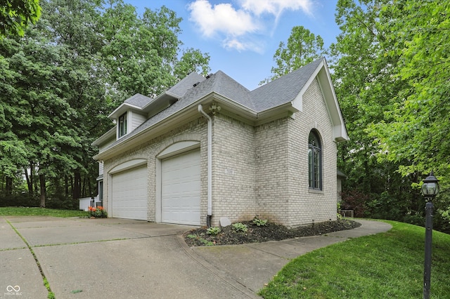 7138 Nile Ridge Ct, Indianapolis, IN 46236 - view of side of property with an attached garage, brick siding, concrete driveway, roof with shingles, and a lawn