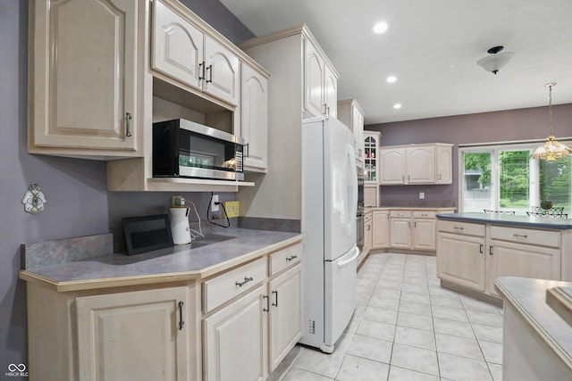 7138 Nile Ridge Ct, Indianapolis, IN 46236 - kitchen featuring stainless steel microwave, freestanding refrigerator, recessed lighting, hanging light fixtures, and light tile patterned floors