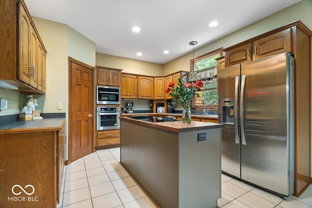 6363 Harmonridge Ct, Indianapolis, IN 46278 - kitchen featuring appliances with stainless steel finishes, a kitchen island, a sink, light tile patterned floors, and recessed lighting
