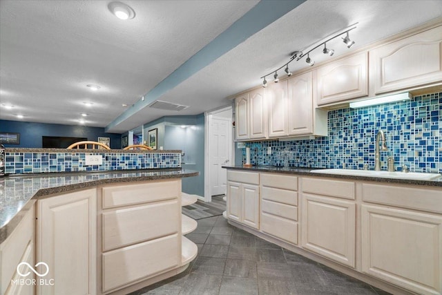 6363 Harmonridge Ct, Indianapolis, IN 46278 - kitchen with tasteful backsplash, dark countertops, a sink, a textured ceiling, and dark tile patterned floors