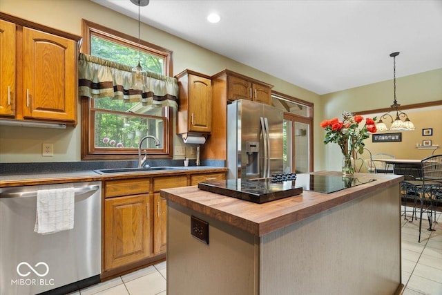6363 Harmonridge Ct, Indianapolis, IN 46278 - kitchen featuring appliances with stainless steel finishes, wood counters, light tile patterned flooring, a sink, and pendant lighting