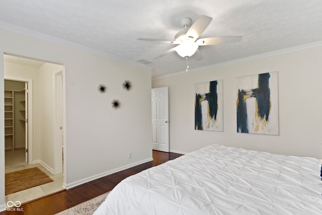 3014 Saddlehorn Dr, Carmel, IN 46033 - bedroom featuring wood finished floors, ornamental molding, a ceiling fan, baseboards, and a walk in closet