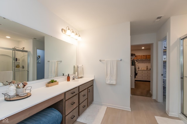 527 Macintosh Ln, Danville, IN 46122 - bathroom with a walk in closet, a shower stall, double vanity, wood finished floors, and recessed lighting