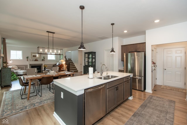 527 Macintosh Ln, Danville, IN 46122 - kitchen featuring appliances with stainless steel finishes, a sink, a fireplace, light countertops, and an island with sink