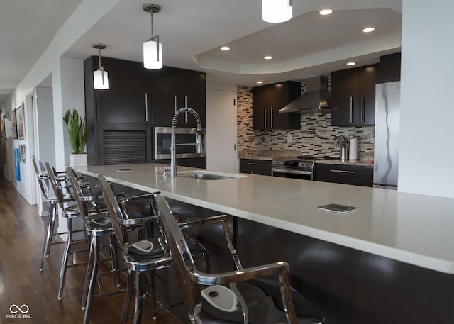 4000 N Meridian St Apt 11D, Indianapolis, IN 46208 - kitchen with wall chimney exhaust hood, stainless steel appliances, dark wood-style floors, decorative backsplash, and light countertops