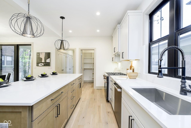 1818 Central Ave, Indianapolis, IN 46202 - kitchen with a sink, stainless steel appliances, light wood-style flooring, white cabinetry, and light countertops