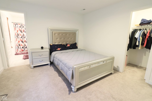 9640 Katana Cir, Fishers, IN 46040 - bedroom featuring light carpet, a walk in closet, a closet, ensuite bathroom, and baseboards
