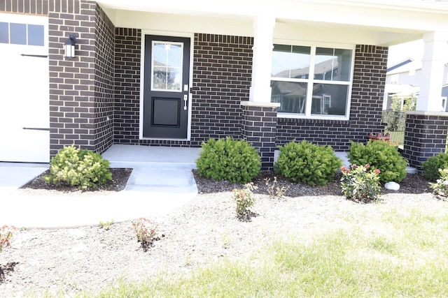 9640 Katana Cir, Fishers, IN 46040 - property entrance with brick siding, covered porch, and a garage