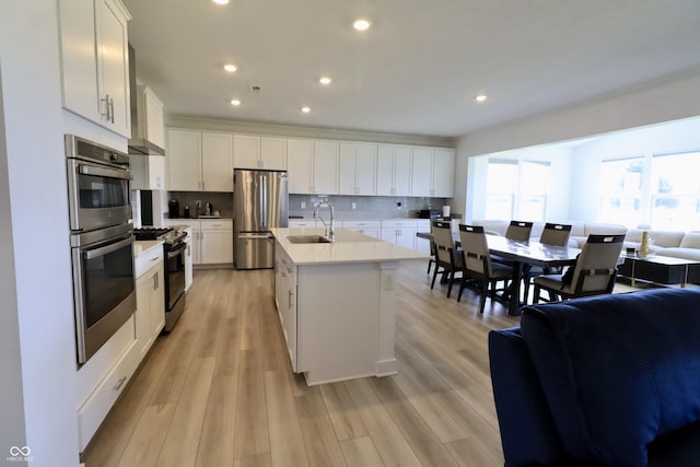 9640 Katana Cir, Fishers, IN 46040 - kitchen featuring appliances with stainless steel finishes, open floor plan, a sink, backsplash, and white cabinetry