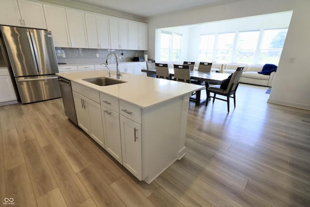 9640 Katana Cir, Fishers, IN 46040 - kitchen with a sink, appliances with stainless steel finishes, light wood-style flooring, white cabinetry, and light countertops