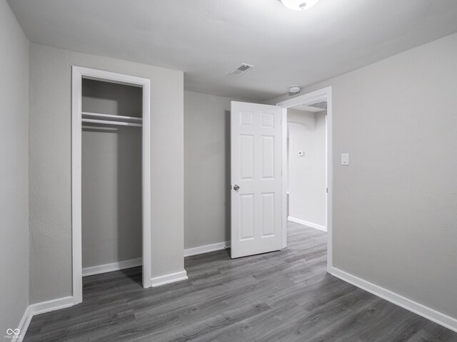 1141 Temperance Ave, Indianapolis, IN 46203 - unfurnished bedroom with dark wood-style flooring, a closet, and baseboards