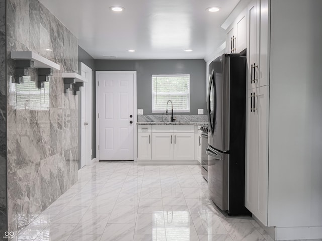 1141 Temperance Ave, Indianapolis, IN 46203 - kitchen with freestanding refrigerator, light stone countertops, white cabinets, recessed lighting, and light marble finish flooring