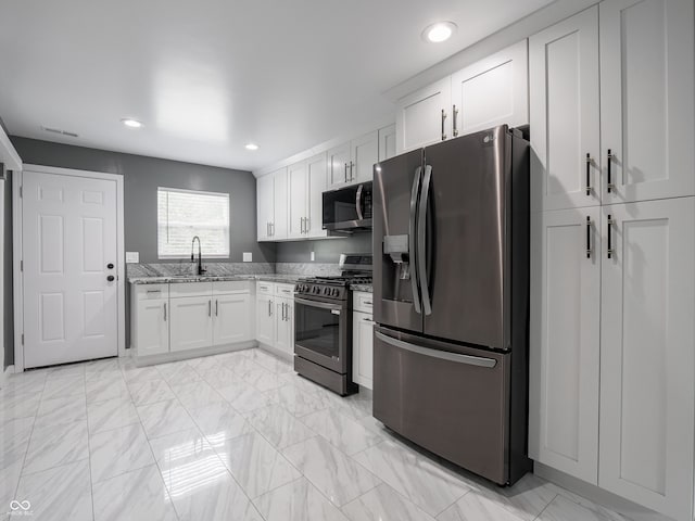 1141 Temperance Ave, Indianapolis, IN 46203 - kitchen with appliances with stainless steel finishes, a sink, light stone countertops, light marble finish flooring, and recessed lighting