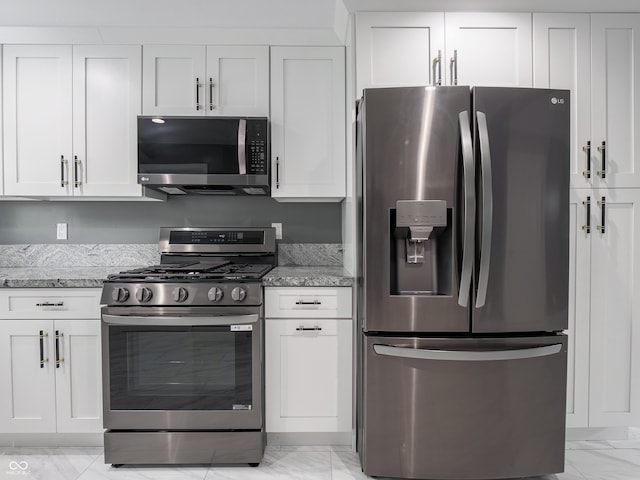 1141 Temperance Ave, Indianapolis, IN 46203 - kitchen featuring stainless steel appliances, light marble finish floors, white cabinetry, and light stone counters