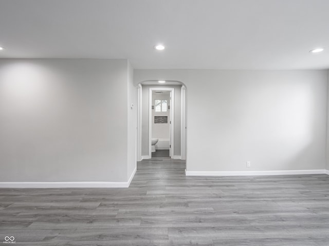 1141 Temperance Ave, Indianapolis, IN 46203 - spare room featuring arched walkways, recessed lighting, wood finished floors, and baseboards