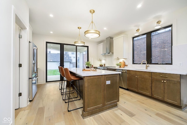 1822 Central Ave, Indianapolis, IN 46202 - kitchen featuring wall chimney range hood, a sink, stainless steel appliances, light wood-style flooring, and recessed lighting