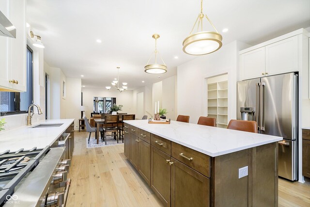 1822 Central Ave, Indianapolis, IN 46202 - kitchen featuring high end fridge, a sink, white cabinetry, light wood finished floors, and a center island