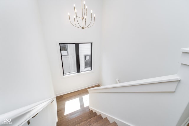 1822 Central Ave, Indianapolis, IN 46202 - staircase featuring a chandelier, wood finished floors, and baseboards