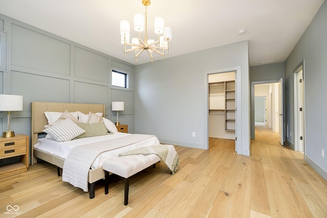 1822 Central Ave, Indianapolis, IN 46202 - bedroom featuring a chandelier, light wood-style floors, a spacious closet, and baseboards