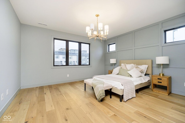 1822 Central Ave, Indianapolis, IN 46202 - bedroom with a chandelier, light wood-style flooring, multiple windows, and baseboards