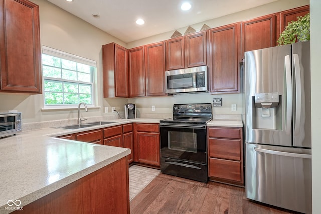 9743 Herons Cv, Carmel, IN 46280 - kitchen with appliances with stainless steel finishes, a sink, light countertops, light wood-style flooring, and recessed lighting