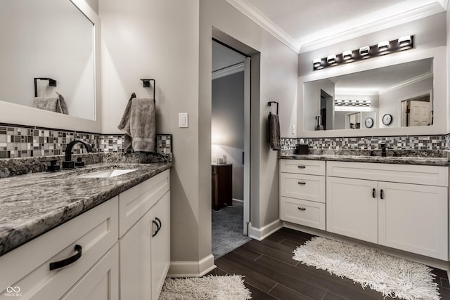 2949 River Bay Dr N, Indianapolis, IN 46240 - full bathroom featuring backsplash, two vanities, wood finished floors, ornamental molding, and baseboards