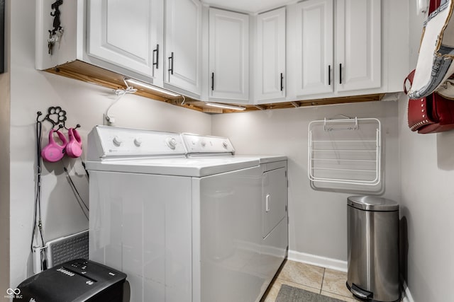 2949 River Bay Dr N, Indianapolis, IN 46240 - laundry area with washing machine and dryer, cabinet space, light tile patterned floors, and baseboards