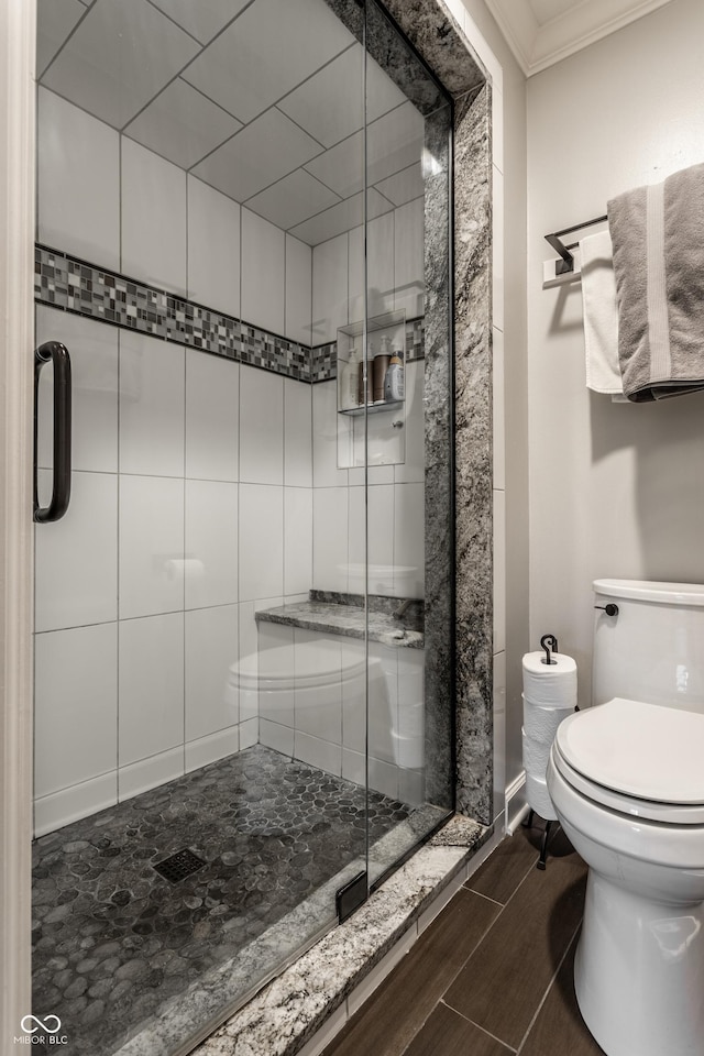 2949 River Bay Dr N, Indianapolis, IN 46240 - bathroom with ornamental molding, wood tiled floors, a shower stall, and toilet
