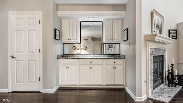 2949 River Bay Dr N, Indianapolis, IN 46240 - bar area with a high end fireplace, baseboards, and dark wood finished floors