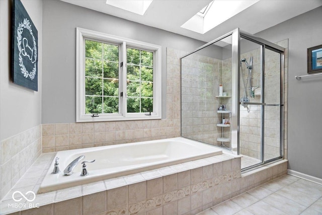 11956 Glen Cove Dr, Indianapolis, IN 46236 - bathroom featuring a skylight, a bath, a shower stall, and tile patterned floors