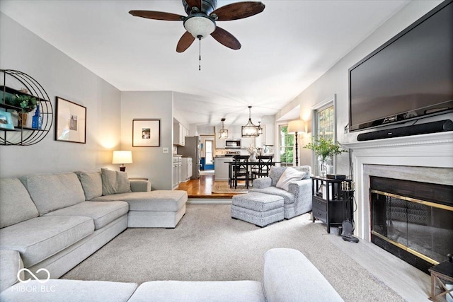 11956 Glen Cove Dr, Indianapolis, IN 46236 - living area featuring light wood-type flooring, ceiling fan, and a premium fireplace