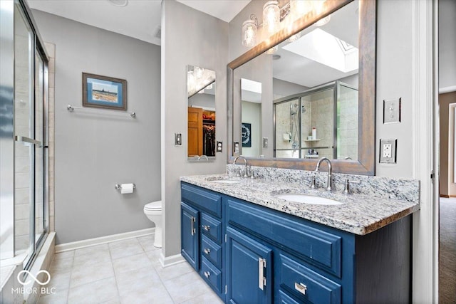 11956 Glen Cove Dr, Indianapolis, IN 46236 - full bathroom featuring a skylight, baseboards, double vanity, tile patterned flooring, and toilet
