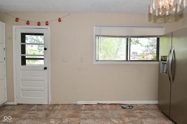 3668 Chatsbee Ct, Indianapolis, IN 46224 - unfurnished dining area with stone finish floors, a chandelier, and baseboards
