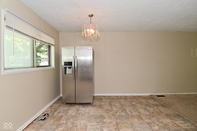 3668 Chatsbee Ct, Indianapolis, IN 46224 - kitchen featuring stainless steel refrigerator with ice dispenser, a chandelier, baseboards, stone finish floors, and hanging light fixtures