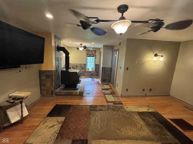 16952 Bookout Rd, Hagerstown, IN 47346 - living area with wood finished floors, a wood stove, ceiling fan, and baseboards
