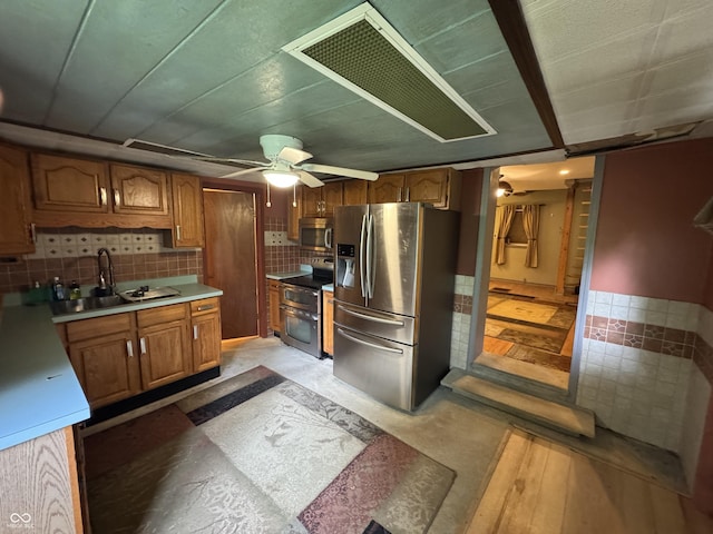 16952 Bookout Rd, Hagerstown, IN 47346 - kitchen featuring stainless steel appliances, brown cabinets, a ceiling fan, a sink, and light countertops