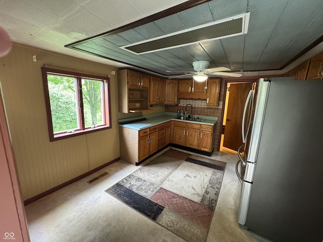 16952 Bookout Rd, Hagerstown, IN 47346 - kitchen featuring freestanding refrigerator, a sink, brown cabinetry, light colored carpet, and light countertops