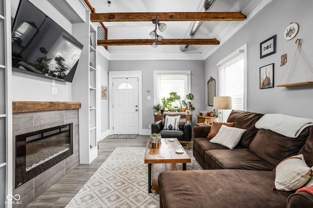 4414 Winthrop Ave, Indianapolis, IN 46205 - living room with wood finished floors, beam ceiling, built in shelves, a tiled fireplace, and baseboards