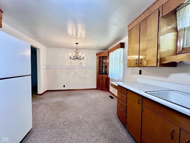 915 Winston Rd, Jonesboro, IN 46938 - kitchen with freestanding refrigerator, light countertops, a chandelier, light colored carpet, and brown cabinets