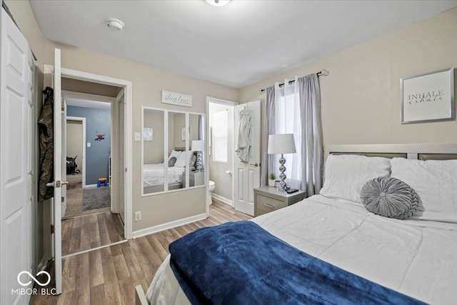 1907 N Drexel Ave, Indianapolis, IN 46218 - bedroom with wood finished floors, baseboards, and ensuite bathroom