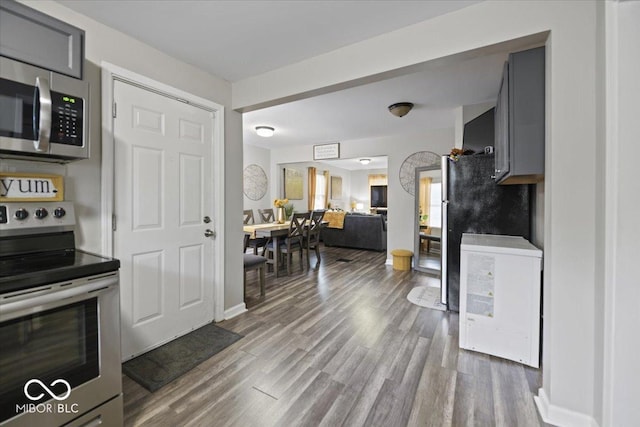 1907 N Drexel Ave, Indianapolis, IN 46218 - kitchen with stainless steel appliances, wood finished floors, gray cabinetry, baseboards, and open floor plan