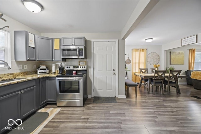 1907 N Drexel Ave, Indianapolis, IN 46218 - kitchen with stainless steel appliances, gray cabinets, a sink, and healthy amount of natural light