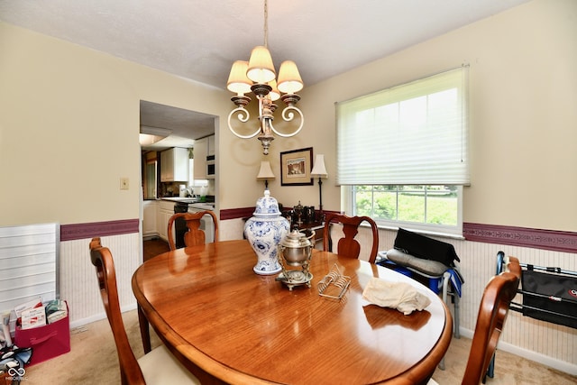 1102 Fox Hill Dr, Indianapolis, IN 46228 - dining room featuring light colored carpet, wainscoting, and a chandelier