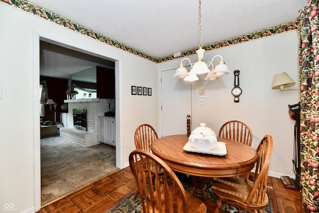 1102 Fox Hill Dr, Indianapolis, IN 46228 - dining room with a chandelier, dark carpet, baseboards, and a fireplace