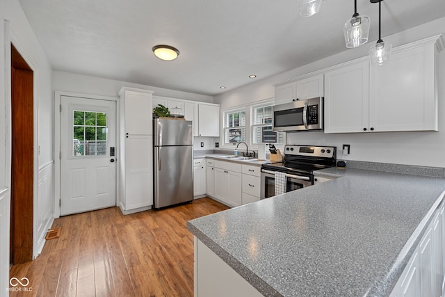 1438 Adams St, Lafayette, IN 47905 - kitchen with appliances with stainless steel finishes, a sink, light wood-style floors, white cabinetry, and recessed lighting