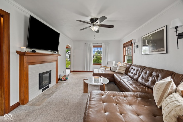 1438 Adams St, Lafayette, IN 47905 - carpeted living area featuring arched walkways, a ceiling fan, baseboards, a tile fireplace, and ornamental molding