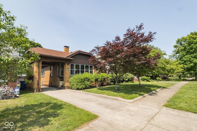 2514 Crawford St, Terre Haute, IN 47803 - view of front of house featuring a chimney, a front lawn, driveway, and brick siding