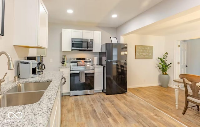 1398 Clinton St, Noblesville, IN 46060 - kitchen featuring stainless steel appliances, a sink, white cabinets, light wood-style flooring, and recessed lighting